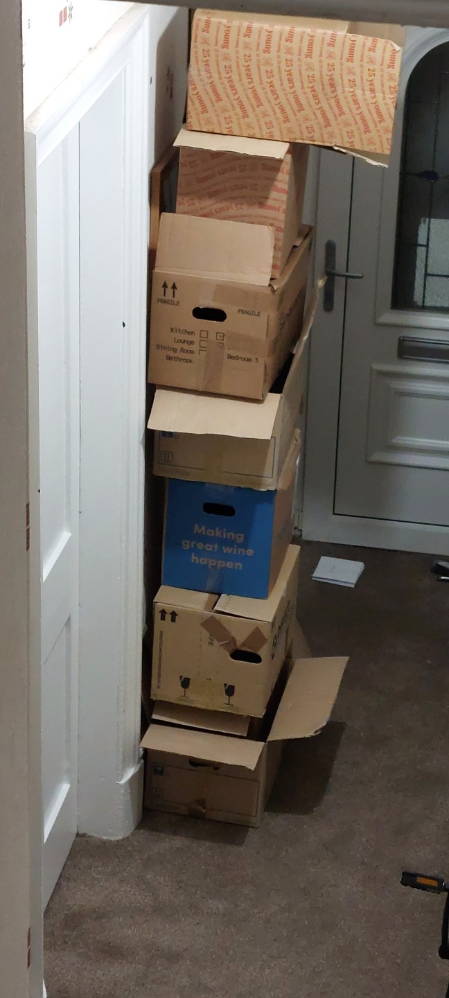 Very tall pile of empty cardboard boxes