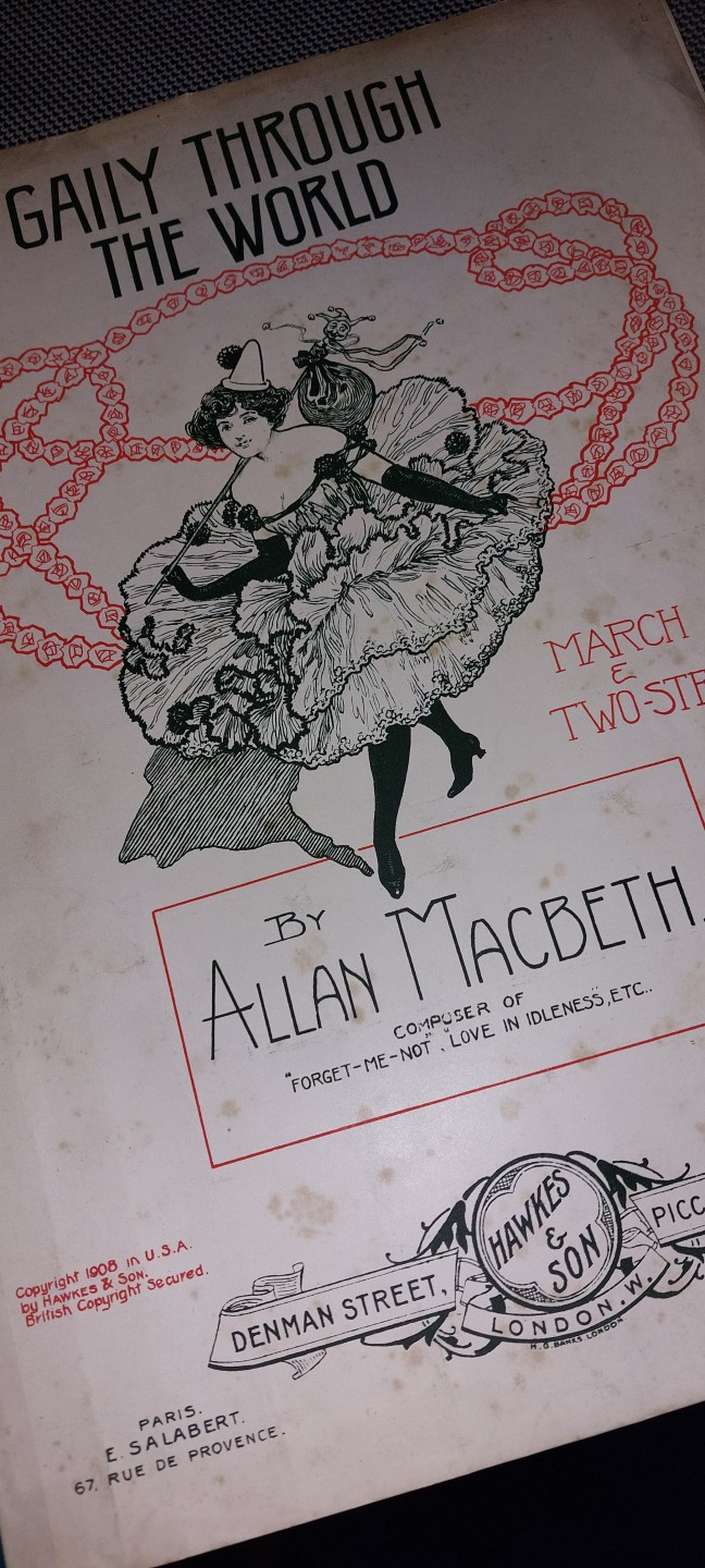Gaily through the World - piano music by Allan Macbeth, with a picture of a woman dancing, on the front cover