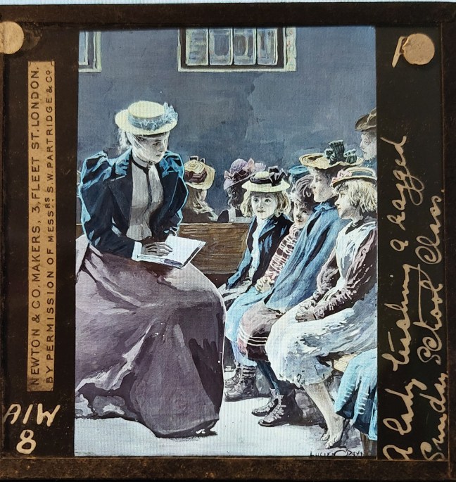 A Vctorian lady teaching children in a ragged Sunday School.