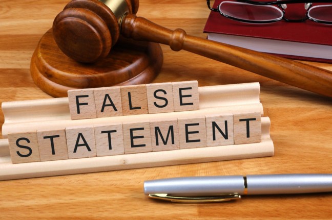 Scrabble letters spelling 'False Statement'. Also on the table, a gavel and a pen.