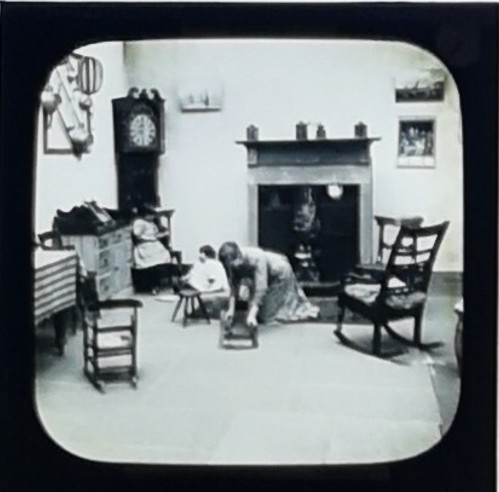 First slide of Biddy, showing servant girl scrubbing the floor.